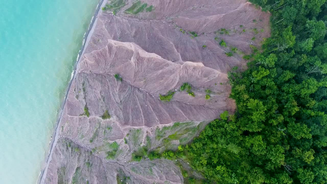A 4K drone shot over the large clay formations of Chimney Bluffs State Park, on the water's edge of Lake Ontario, in the town of Huron, New York