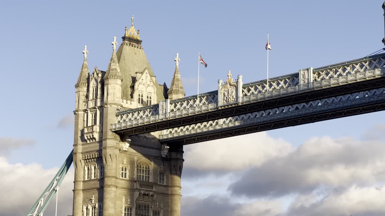 Union Jack and England Flag blowing on top of London's iconic Tower Bridge at golden hour, sunset - London, UK