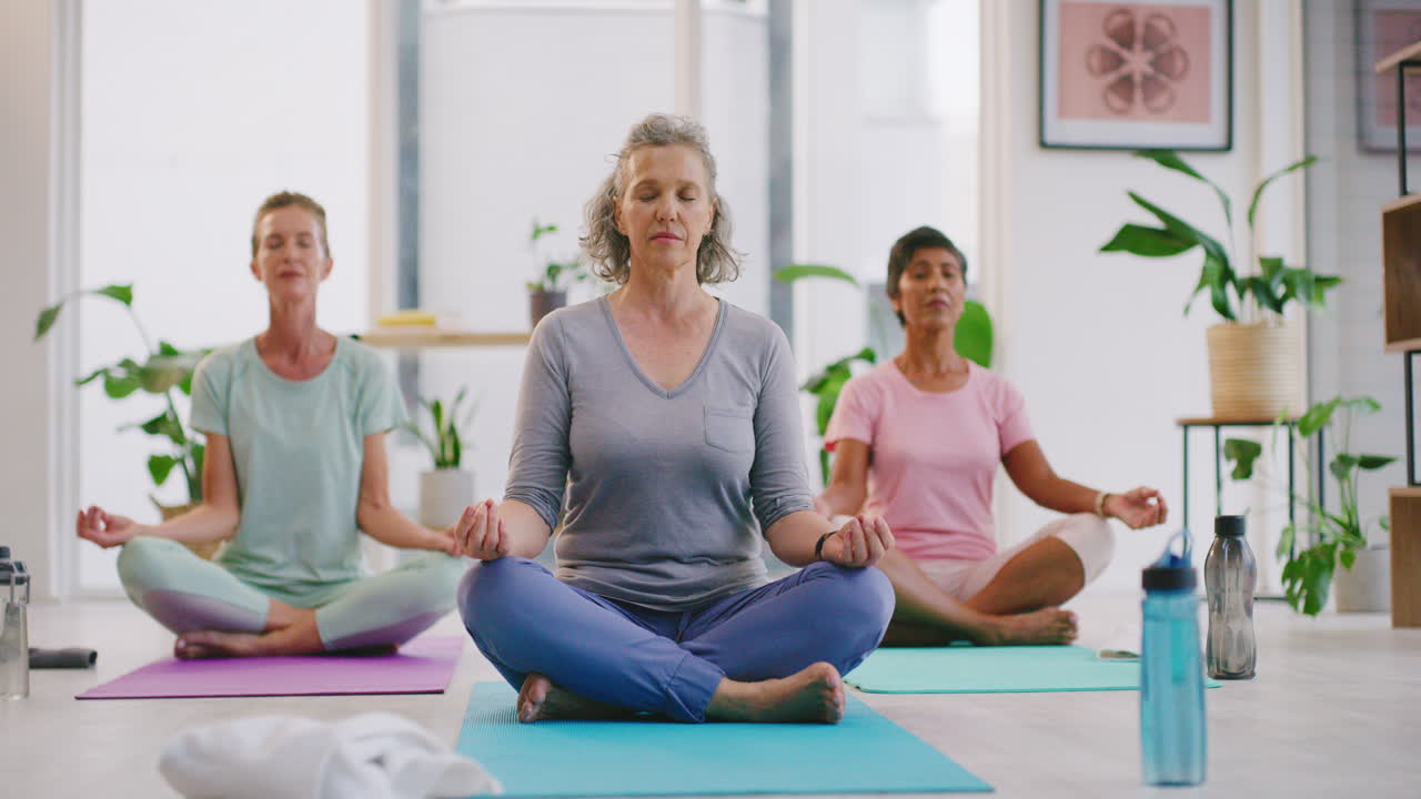 mujeres maduras meditando en la postura del loto en el yoga zen