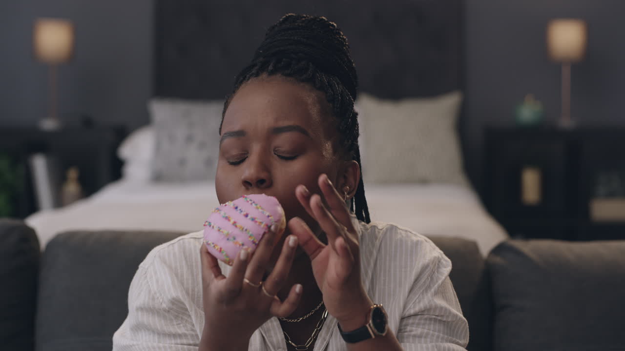 una giovane donna che mangia un cupcake mentre è seduta