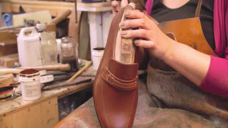 bespoke shoemaker staining and polishing leather of shoe