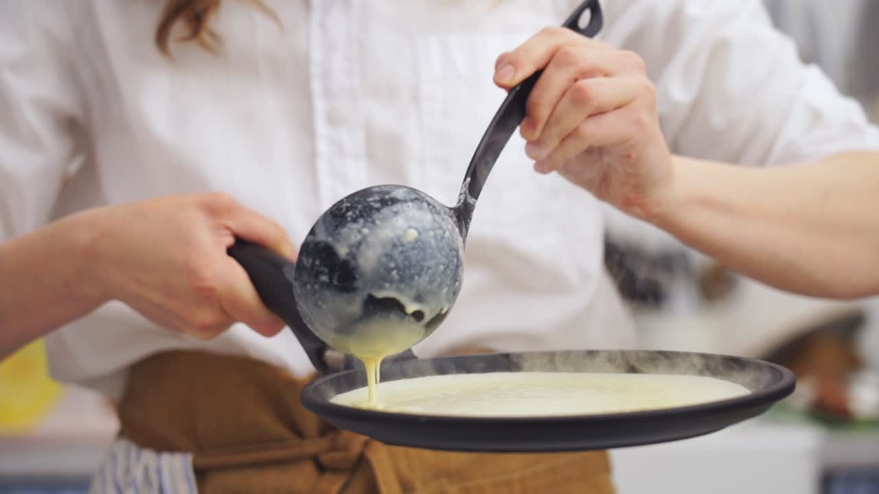 ⁇ 에 팬케이크를 위한 반죽을 넣고 있는 익명의 요리사