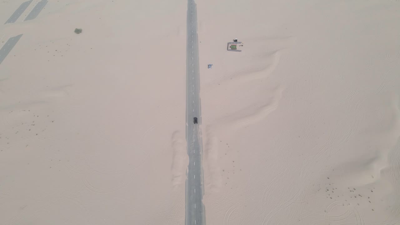 두바이의 고속도로에서 과속하는 검은색 슈퍼카의 위쪽 전망, 사막을 위로 기울이기