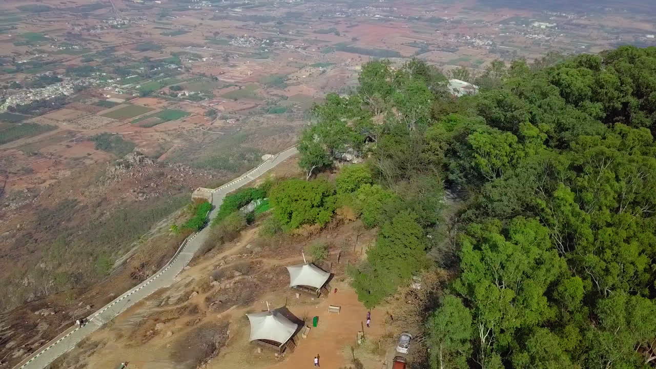 Top shot of tourists at viewpoint to enjoy look of Nandi Hills during daytime in Karnataka, India. 4k. Drone footage.