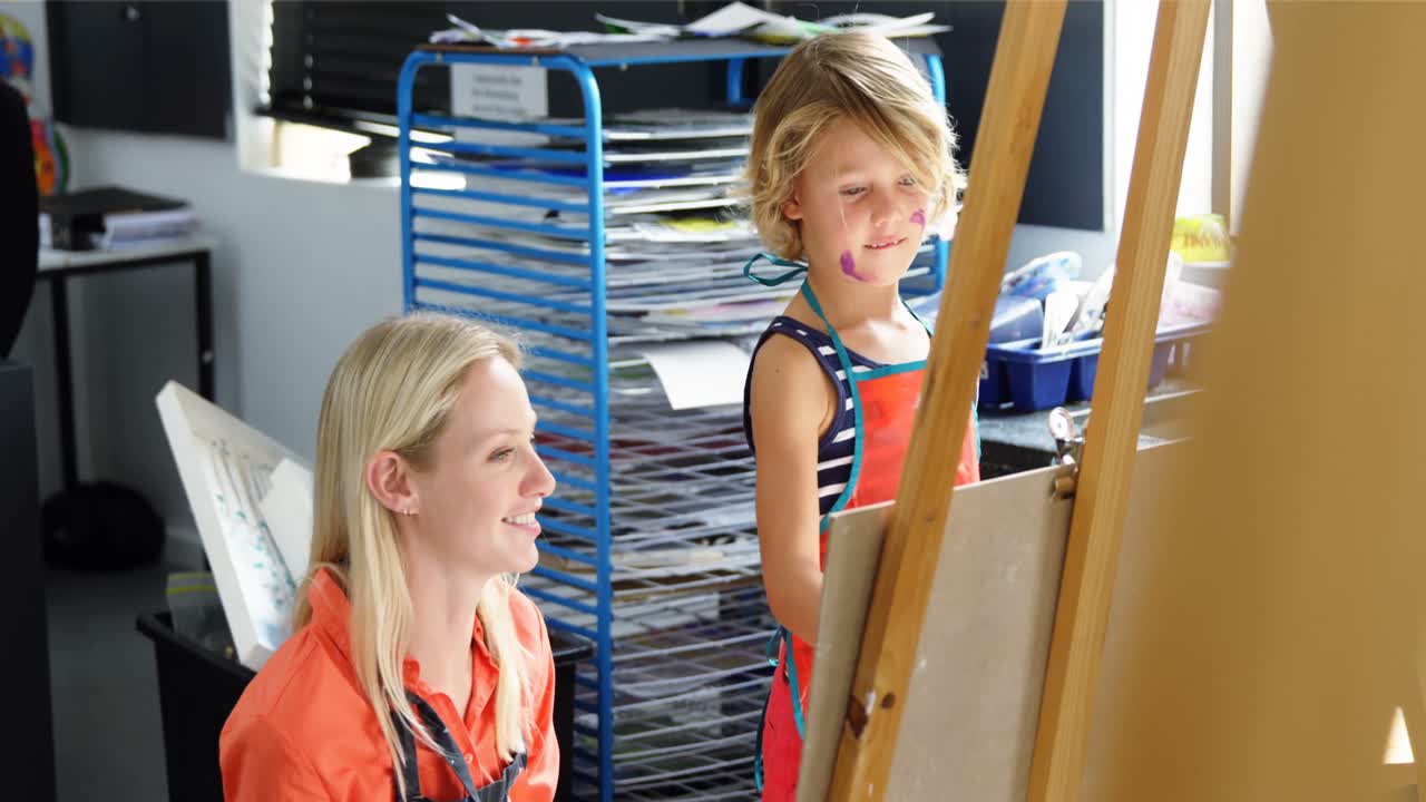 Leerkracht helpt schoolmeisje in tekenles