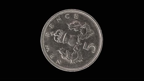 united kingdom 1970 five new pence coin reverse with crowned thistle badge rotating on black background