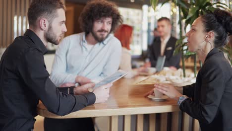 business coworkers having a meeting in a cafe shop, smiling and discussing business during a work break