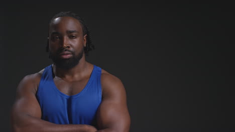 Studio-Portrait-Of-Smiling-Male-Athlete-Wearing-Vest-Sport-Training-Or-Exercising-In-Gym-Folding-Arms-With-Copy-Space