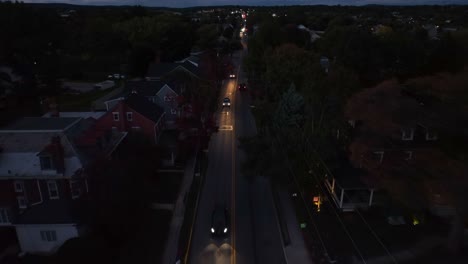 Cars-driving-on-main-street-in-American-town-at-night