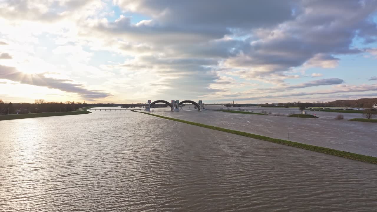 Approach drone shot of the weir of Driel during high water levels during the sunset