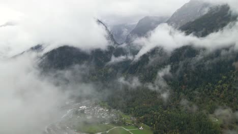drone flying over a small village in switzerland called bondo (bregaglia) in upper engadine, grisons, in a foggy day.