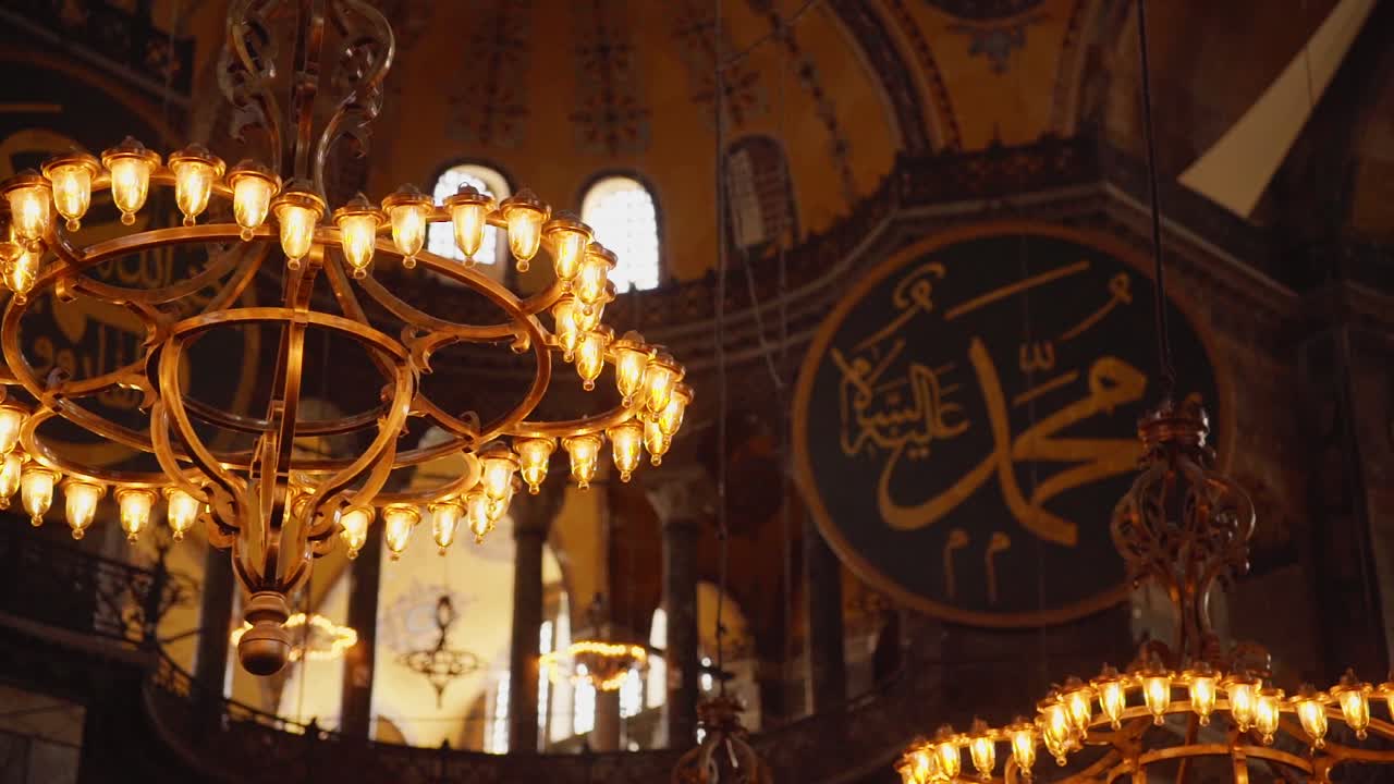 candelabros antiguos y caligrafía islámica dentro de la gran mezquita hagia sophia en estambul, turquía