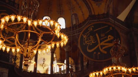 old chandeliers and islamic calligraphy inside the hagia sophia grand mosque in istanbul, turkey