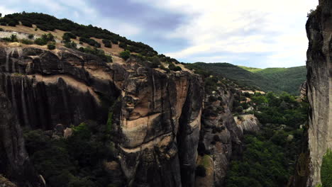 Volando-Hacia-Atrás-Entre-Impresionantes-Formaciones-Rocosas-Rodeadas-De-Naturaleza-Y-Otras-Formaciones-Rocosas---Cielo-Nublado-En-El-Fondo