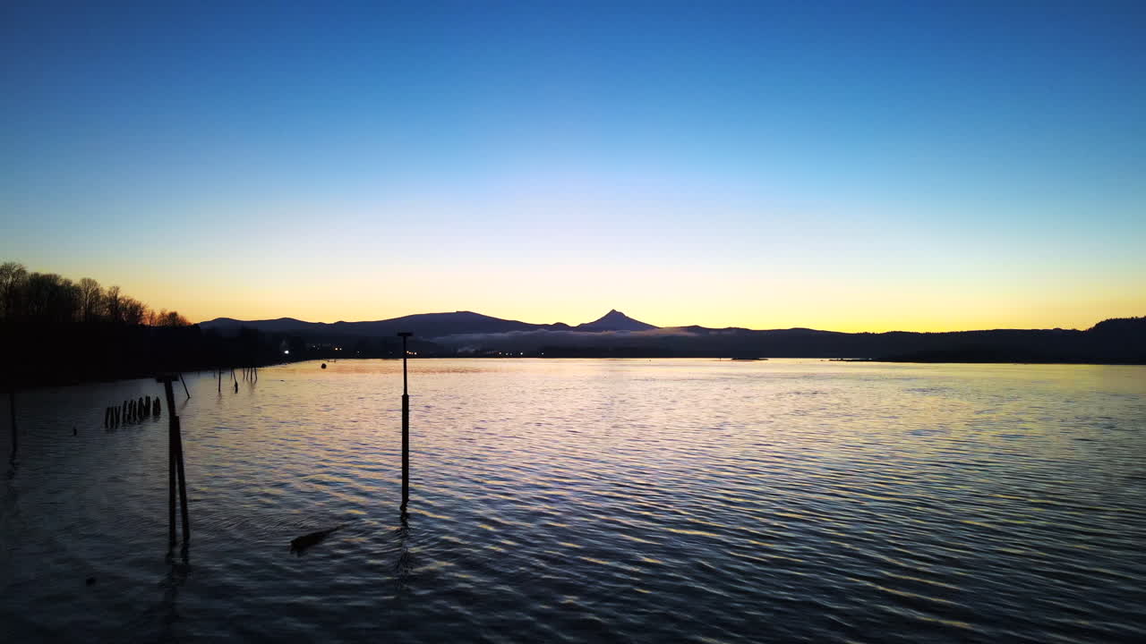 멋진 호수 위를 천천히 떠다니는 드론, 멋진 일몰 동안 물에 잔물결