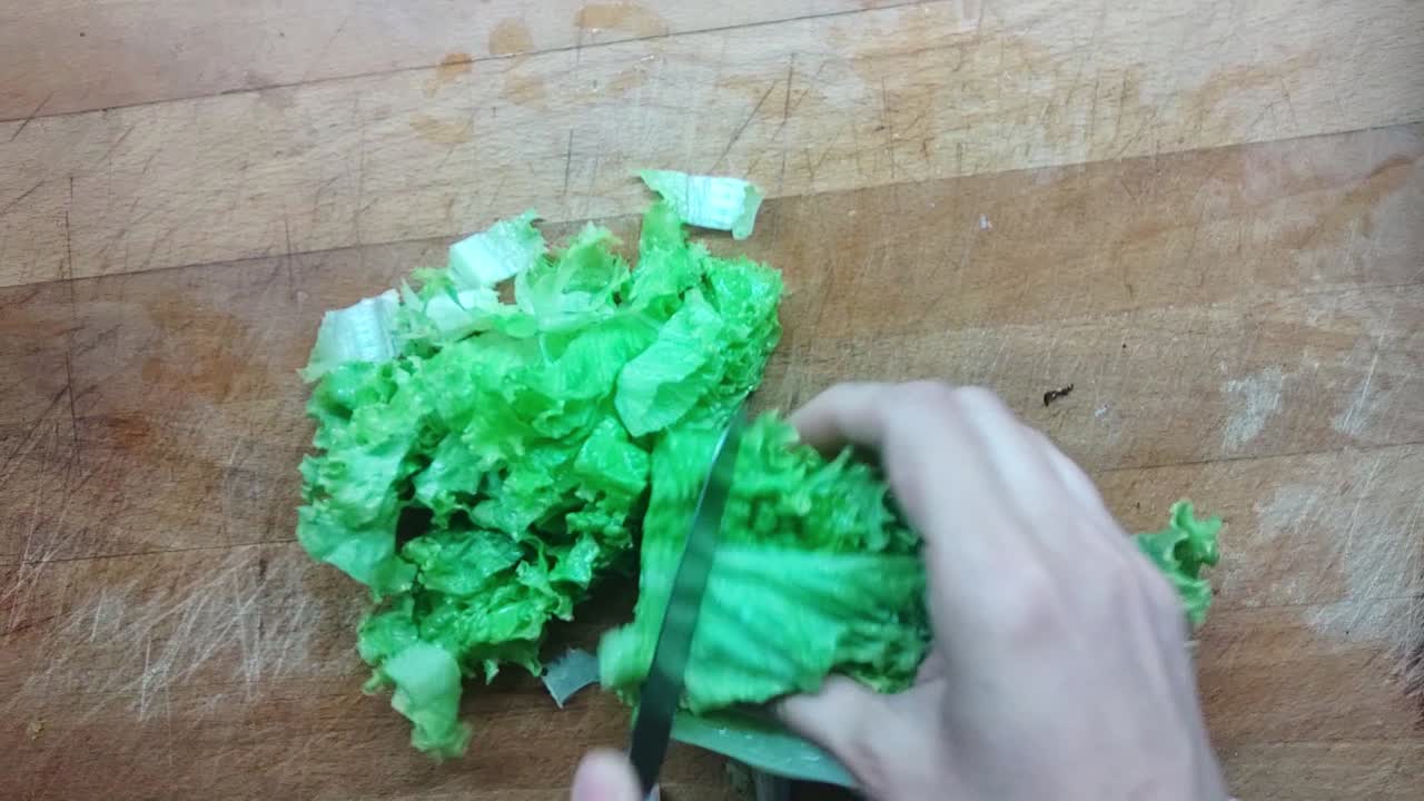 preparación de alimentos: cortar repollo fresco en una superficie de madera para un plato de ensalada verde