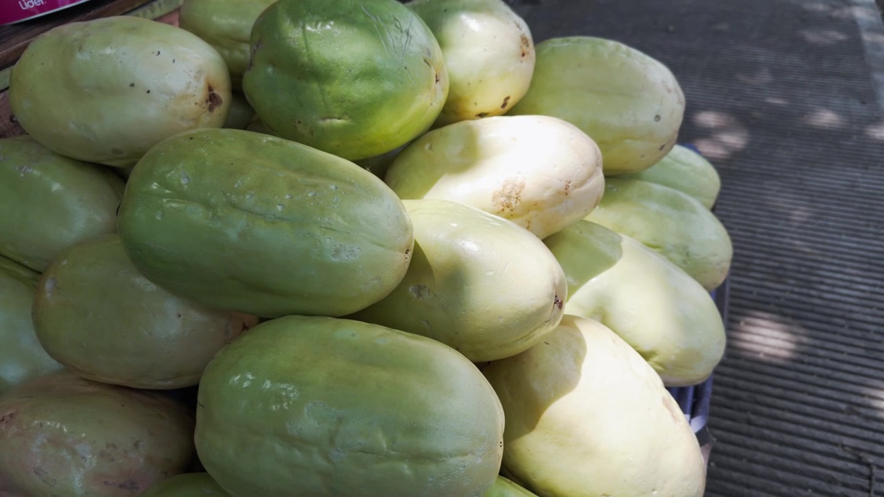 Primo piano di un mucchio di granadille fresche e dolci, un tipo di frutto della passione, in vendita al mercato locale