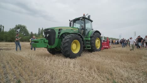 demostración de maquinaria agrícola en una exposición. los tractores operan en el campo, mostrando sus capacidades y rendimiento en acción