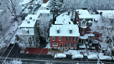 Brick-home-with-light-on-at-night-during-winter-snow-flurries