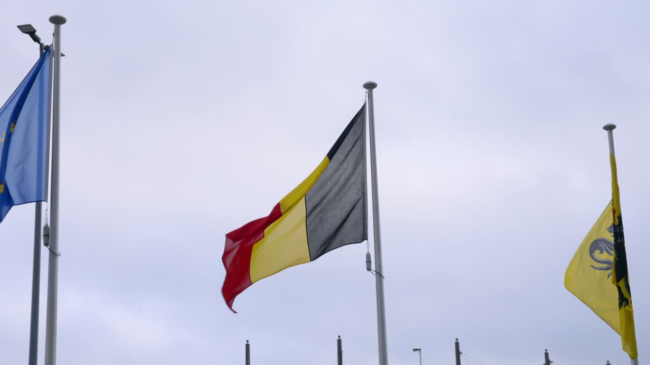 Waving flag of Belgium against a cloudy sky The flag is a national symbol of Belgium representing the country's government politics and Belgian culture