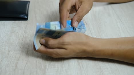 man counting  rupiah notes