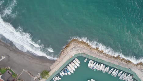 Vista-Aérea-De-Arriba-Hacia-Abajo-De-Una-Playa-En-Playa-Candado,-Málaga,-España-Con-Un-Muelle-Cercano