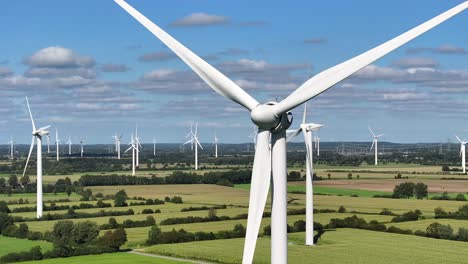 wind turbines farming wind energy, closeup telephoto shot, many turbines spinning in the background, green sustainable power, slow drone orbit