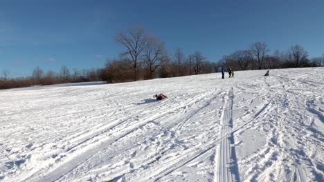 a kid sliding downhill on a plastic board