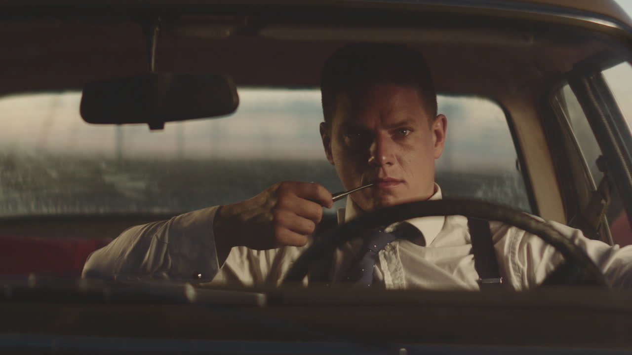 레트로 자동차에서 파이프를 피우는 남자