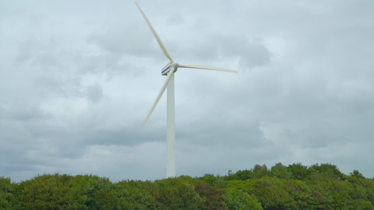 풍력 터빈이 회색 구름진 밝은 하늘을 향해 바람이 부는 구름진 여름날