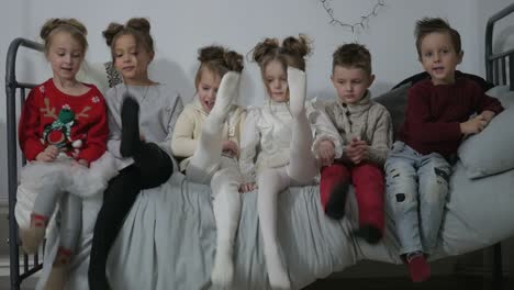 kids playing and kicking legs on a bed