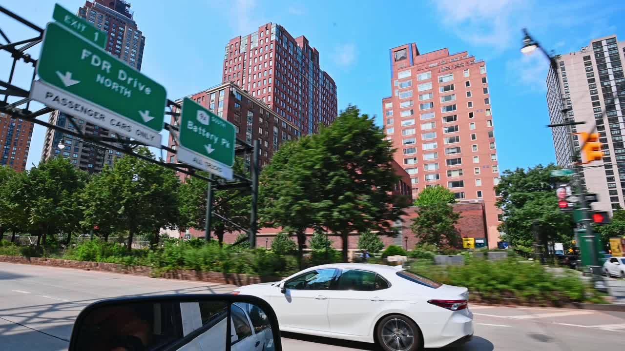 Nova York, EUA, 9 de agosto de 2025: Desfoque de movimento de um quiosque de segurança e de um edifício de tijolos vermelhos. Vista da rua de um veículo em movimento, mostrando uma guarita verde e arquitetura residencial de arranha-céus com árvores.