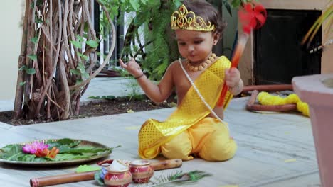 adorable bebé vestido como el dios hindú krishna linda expresión facial con flauta en janmashtami