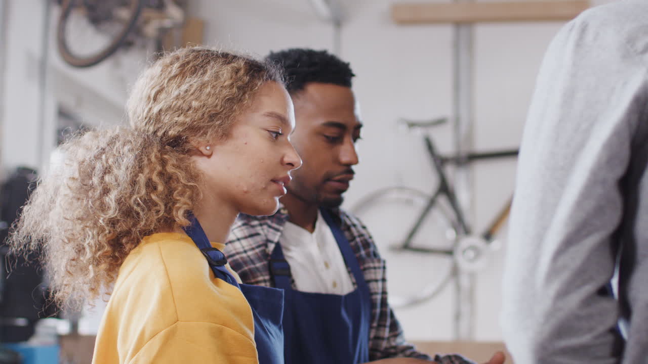 Team Of Trainees In Workshop Learn How To Assemble Hand Built Bicycle Frame Together