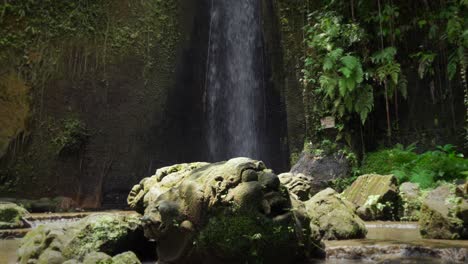 art carved stones sculpture of mask faces demons balinese culture sumampan waterfall bali