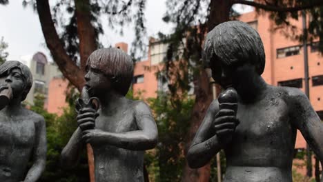 Skulptur-Von-4-Jungen,-Die-In-Einem-Park-Essen