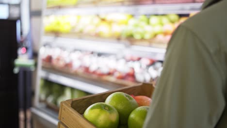 close-up of male hands holding wooden box of vegetables along the counters indoor