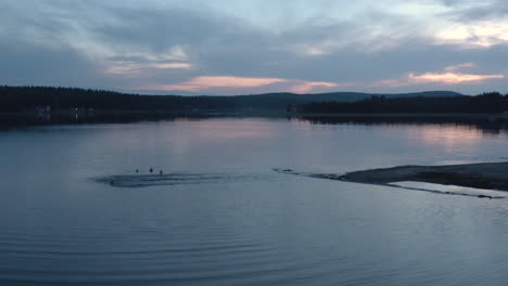 4k drone shot of young people running out in to a lake