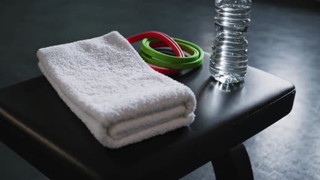 gym essentials: water bottle, resistance bands, and towels.