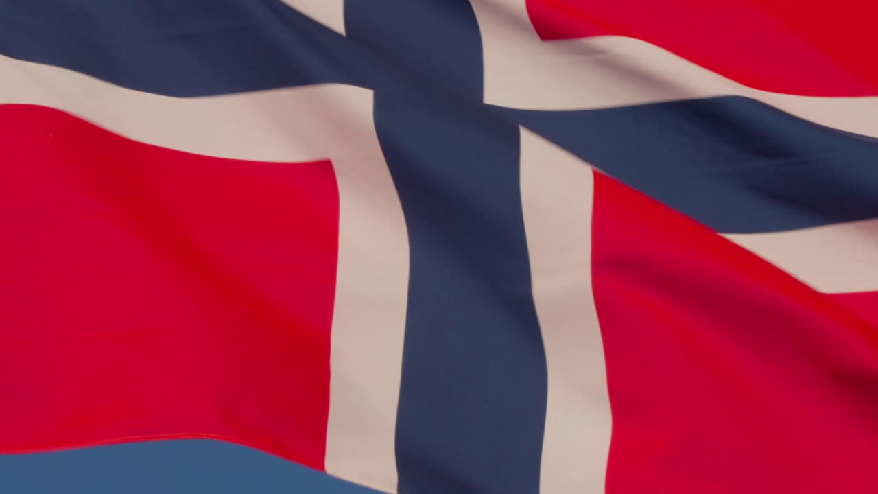 Closeup of the Norwegian flag waving in the wind against a clear blue sky. Captured in Oslo, Norway (Oslo, Norge)