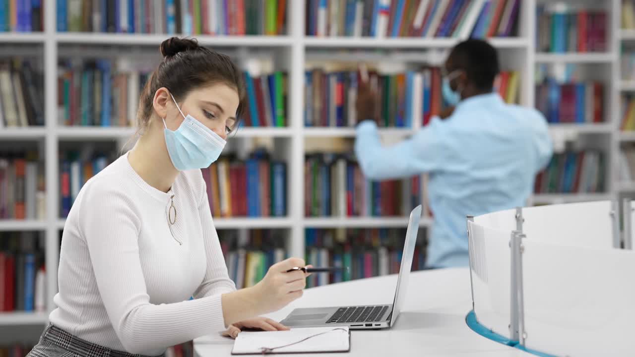 Students working in a library during COVID-19