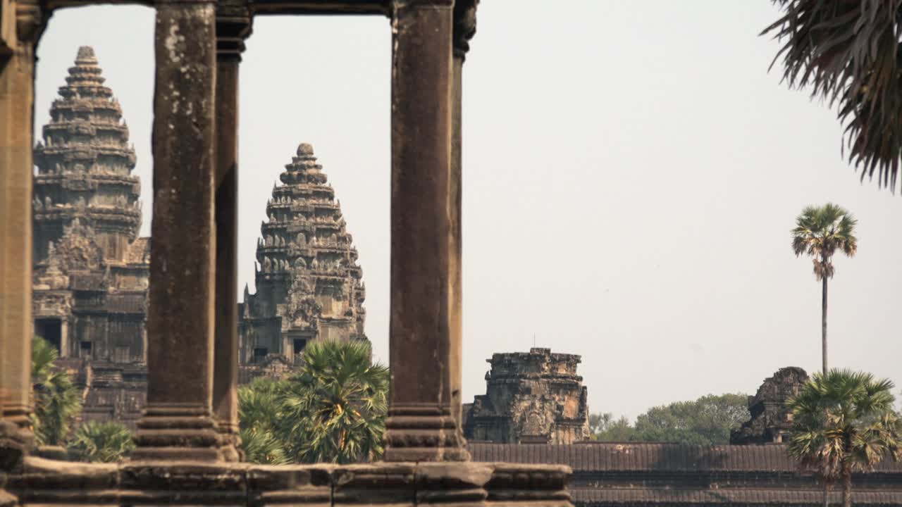 Medium Exterior Timelapse Shot of Angkor Wat Towers Through Column