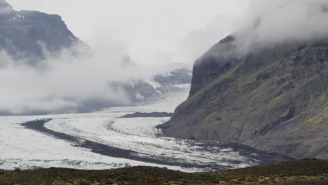 slow dolly-out shot of the cloud-covered mountain peaks of fjallsárlón in iceland