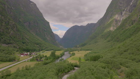 aerial up scenic gudvangen valley - kjelfossen cascading down steep mountainside