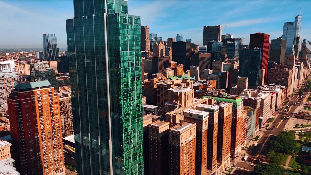 Vista da lontano del moderno grattacielo di vetro che svetta sopra gli edifici a più piani vicini tra loro. Vista sull'architettura di Chicago, Illinois, Stati Uniti