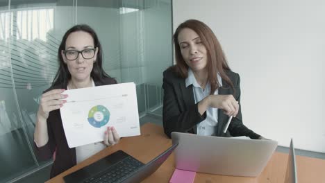 confident businesswomen sitting and talking about charts