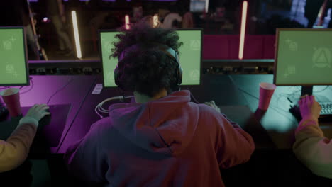 Rear-View-Of-Cybersport-Gamers-Playing-Virtual-Video-Games-On-Professional-Computer-With-Green-Screen-Display