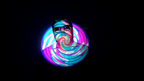 retrato de un hombre gordo en un haz de luz multicolor.