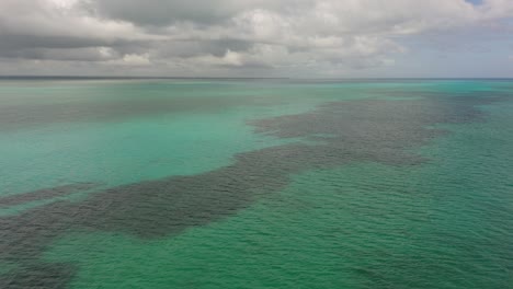 aerial drone fly above blue turquoise ocean water and cloudy skyline of zanzibar