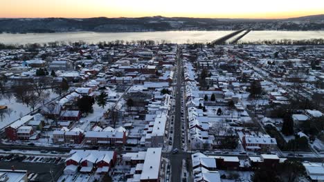 Aerial-approaching-shot-of-snowy-american-town-with-colorful-houses-at-sunset